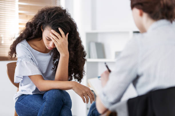 A therapist and a client sitting together in a comfortable setting, supportive atmosphere.